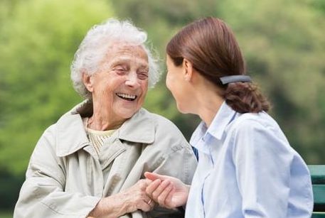 Alte und jüngere Frau im Gespräch auf Parkbank