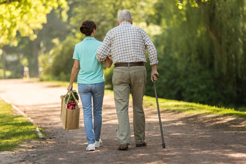 Alter Herr geht mit jüngerer Frau spazieren